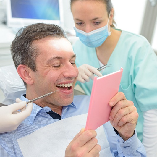 A man looking at his new dental crown