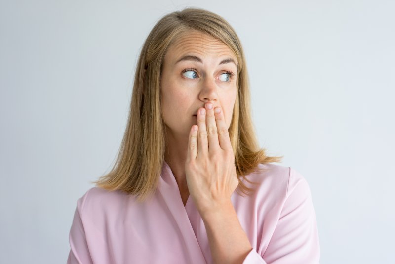 Patient holding hand over mouth due to bad breath